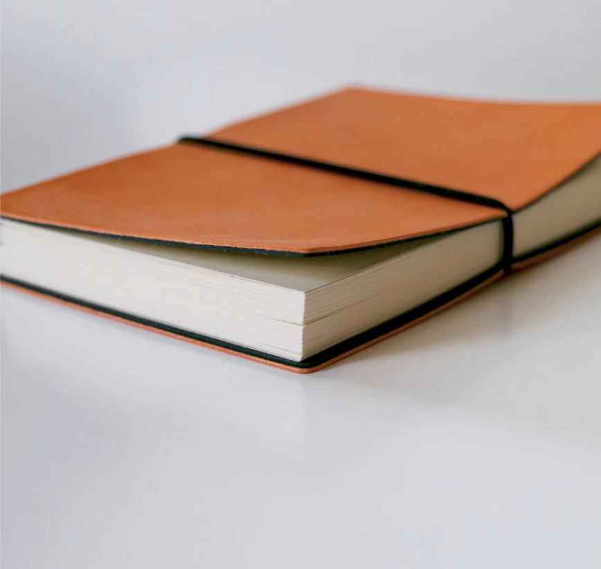 Aufgeschlagenes Notizbuch in Orange-Rot